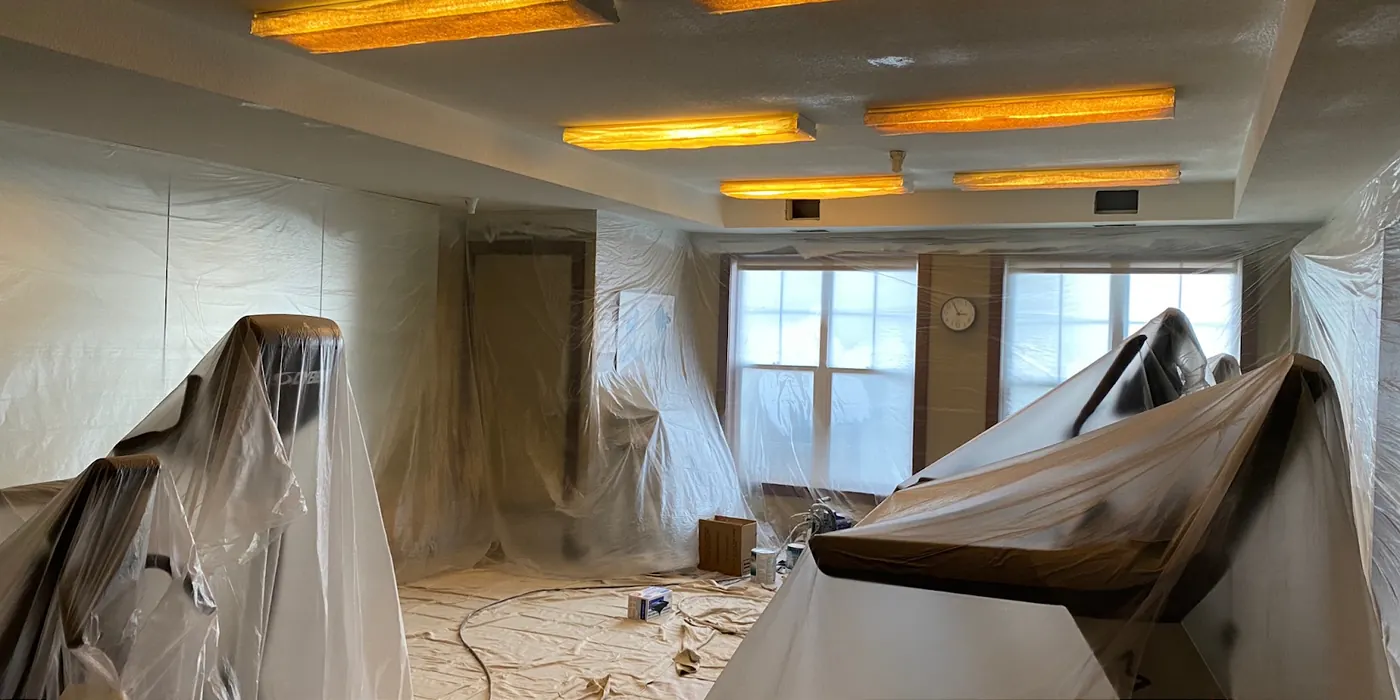 Fitness room covered in plastic containment before painting